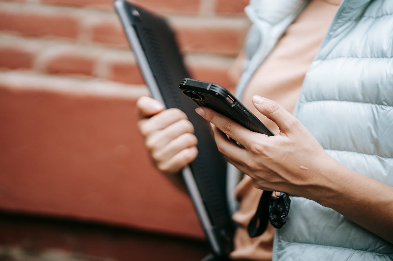 5 Rekomendasi Mobile Device Management untuk Berbagai Industri Ilustrasi karyawan membawa handphone dan laptop. Sumber foto Pexels oleh Sam Lion